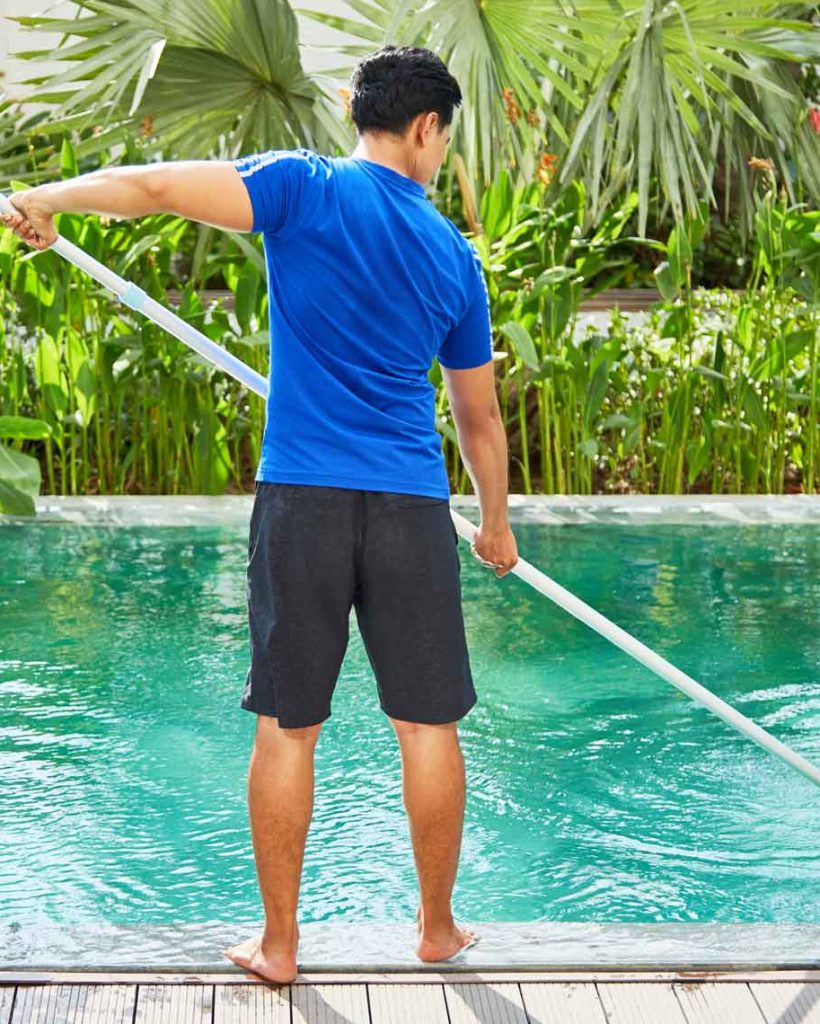 young man cleaning pool in college station
